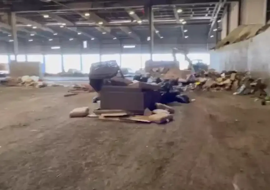 Warehouse Cleanout : A large, cluttered warehouse filled with various items, including cardboard boxes, furniture, and other discarded materials.